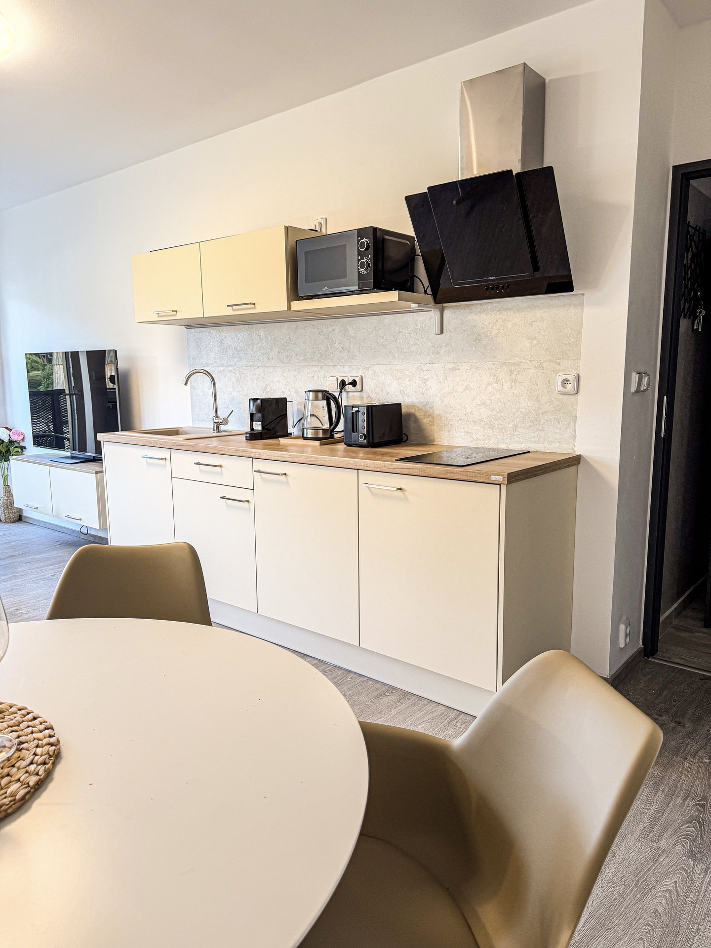 Kuchyňská linka s moderními spotřebiči a jídelním stolem – Apartmány Panorama